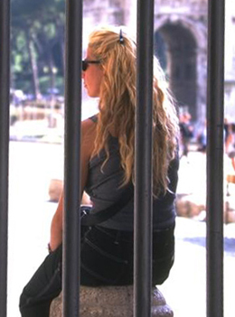 Mujer joven tras una reja